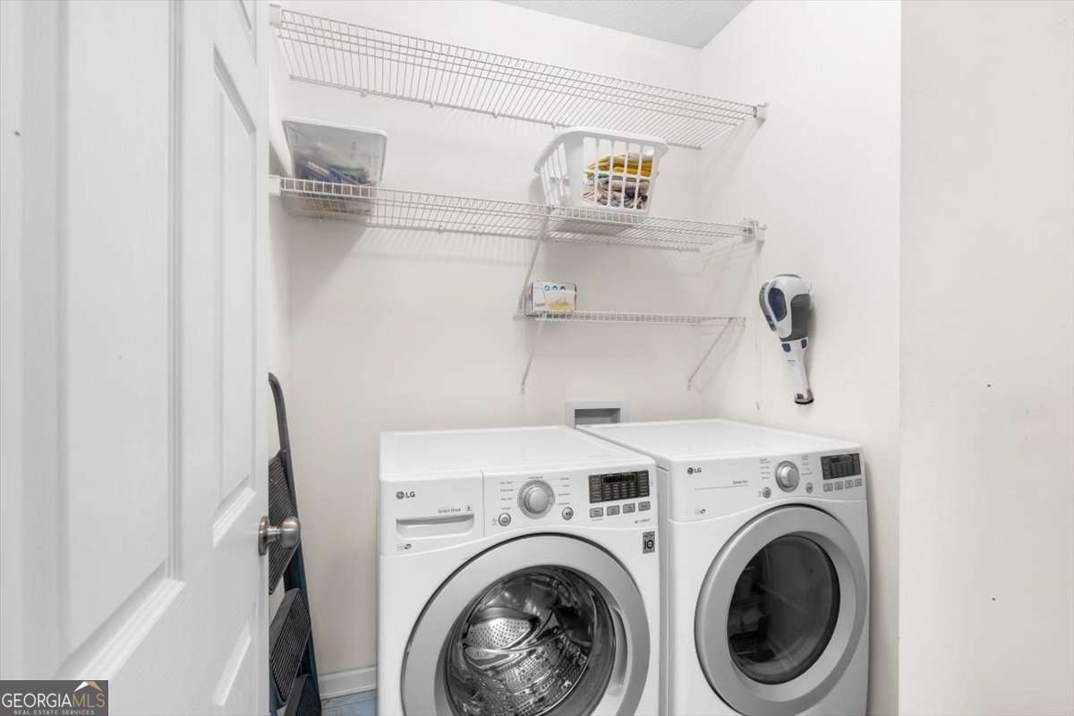 803 Spring Heights Lane, Unit 8 Smyrna, GA 30080 - Photo 27 of 46 a view of washer and dryer with kitchen in the background