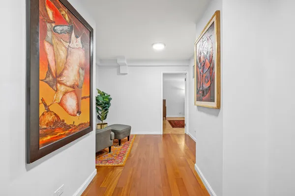 a view of a hallway with wooden floor and furniture