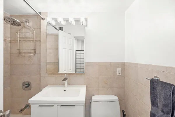 a bathroom with a sink a toilet and shower