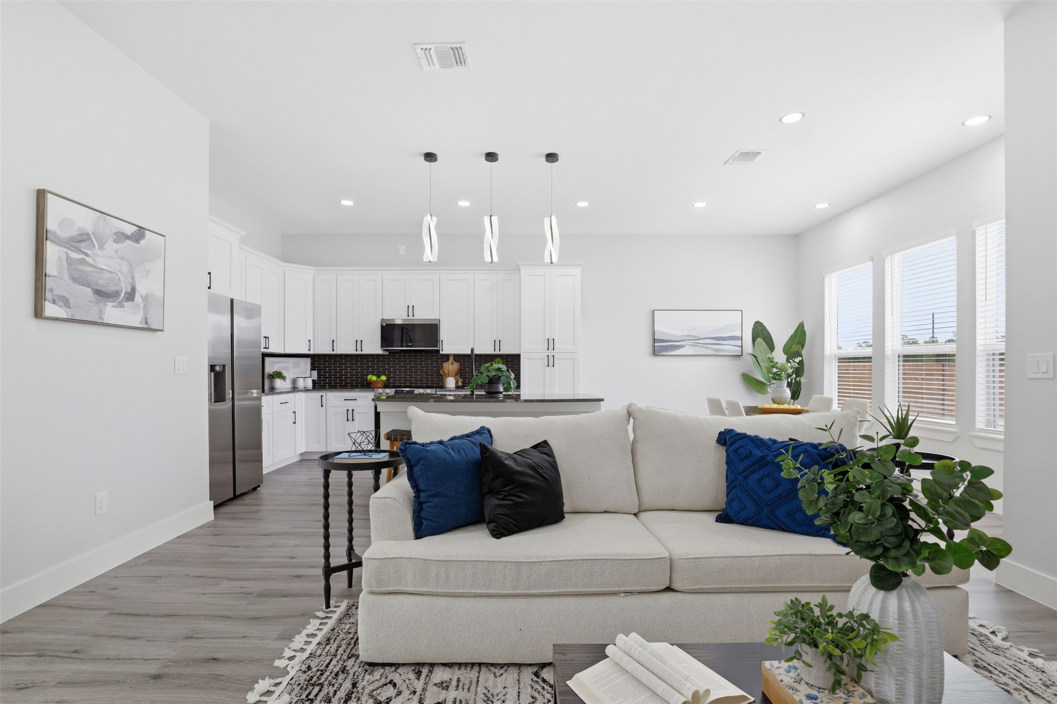 123 Los Robles Road Elgin, TX 78621 - Photo 5 of 21 Open-concept living area featuring wood-finish flooring, recessed lighting, and ample natural light through multiple windows