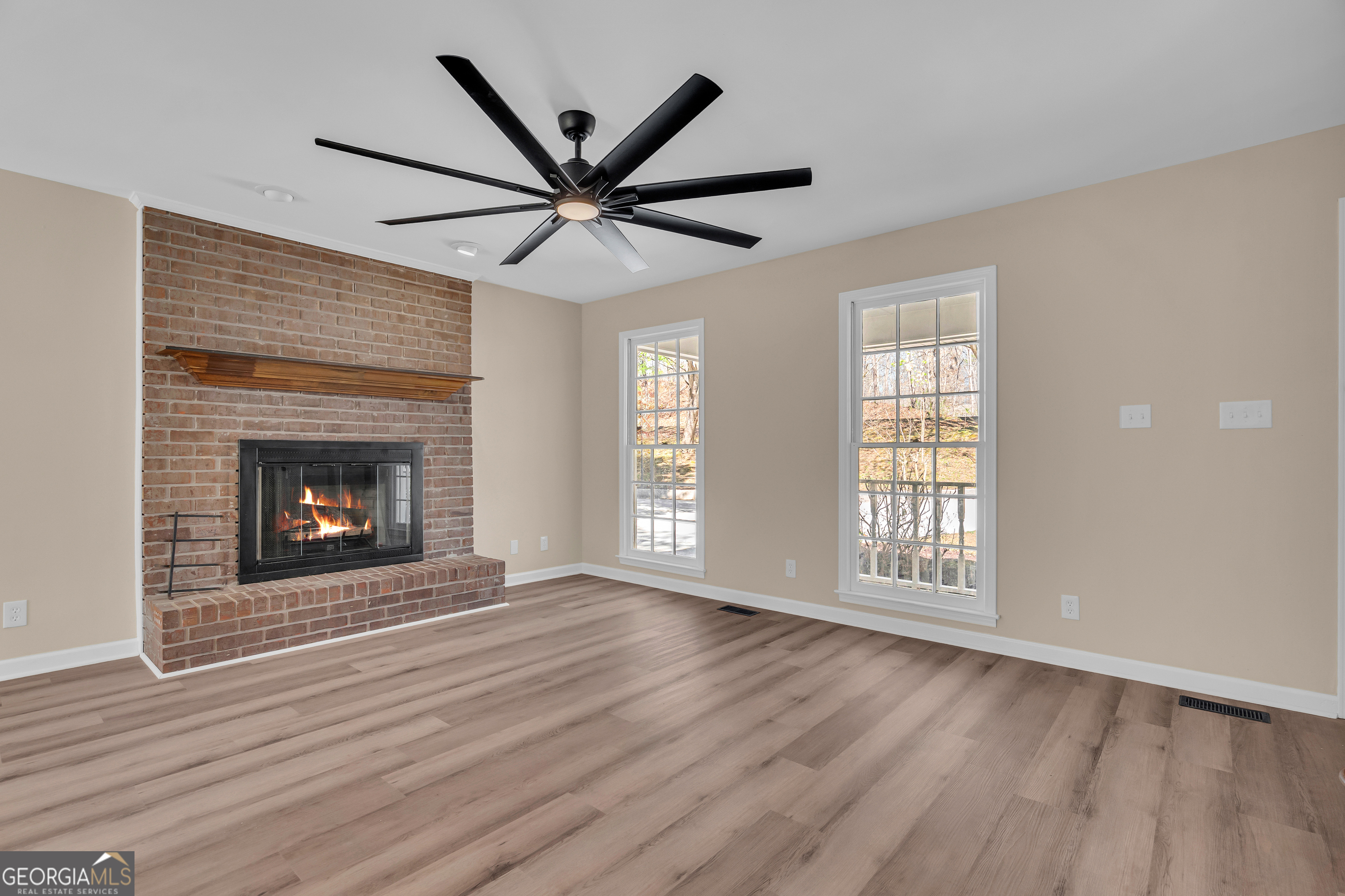 694 Lovers Lane Toccoa, GA 30577 - Photo 21 of 50 a view of an empty room with wooden floor fireplace and a window