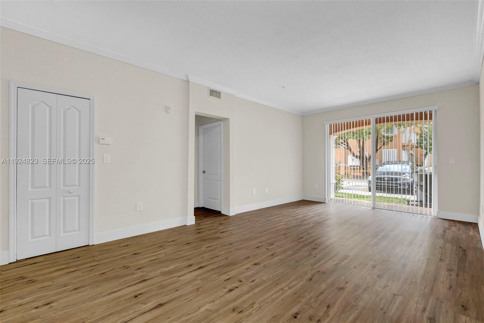 7250 Northwest 177th Street, Unit 10216 Hialeah, FL 33015 - Photo 11 of 23 a view of an empty room with wooden floor and a window
