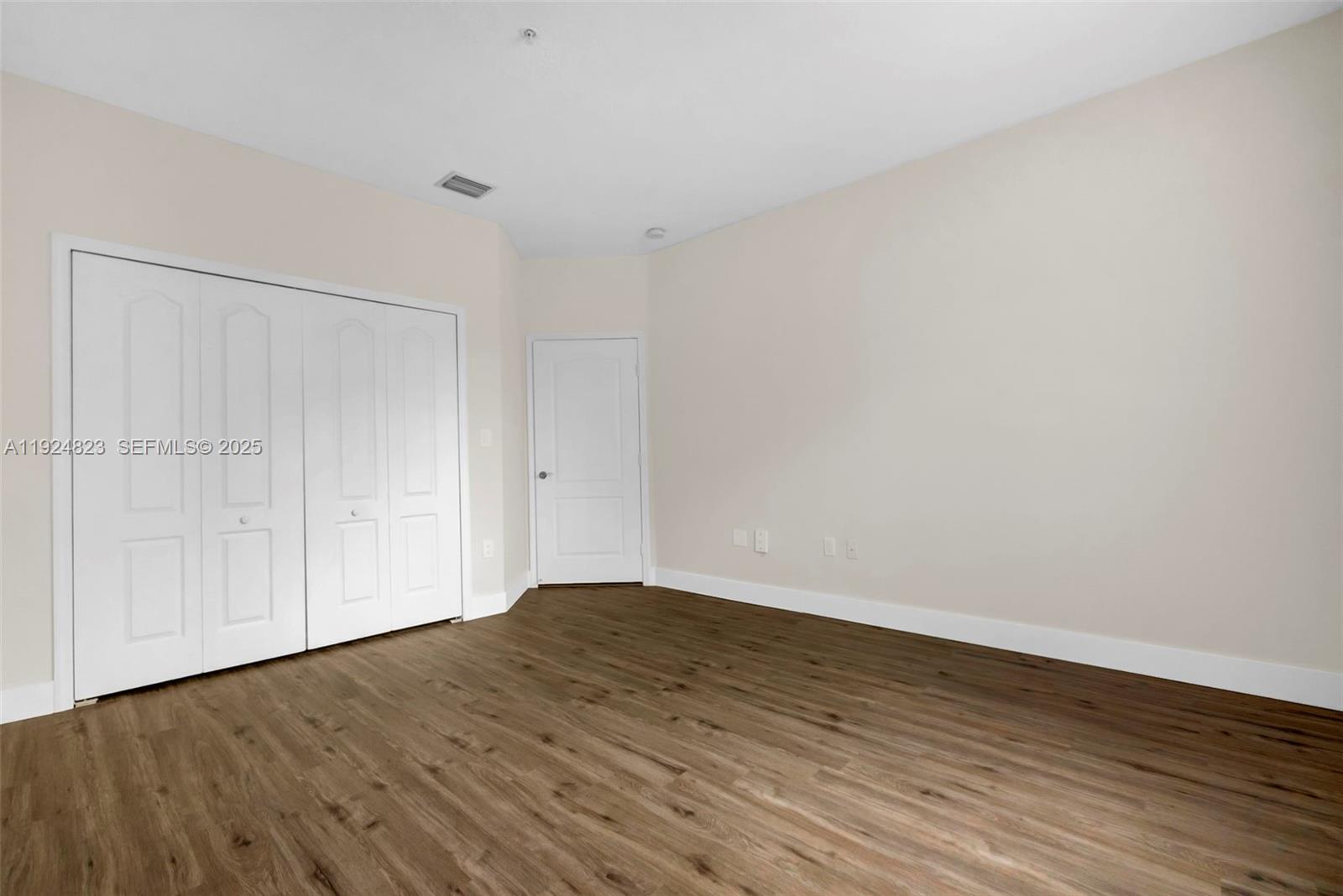 7250 Northwest 177th Street, Unit 10216 Hialeah, FL 33015 - Photo 13 of 23 a view of an empty room with wooden floor