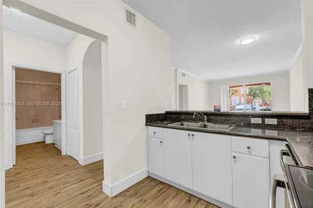 a kitchen with stainless steel appliances granite countertop a stove a microwave and a white cabinets