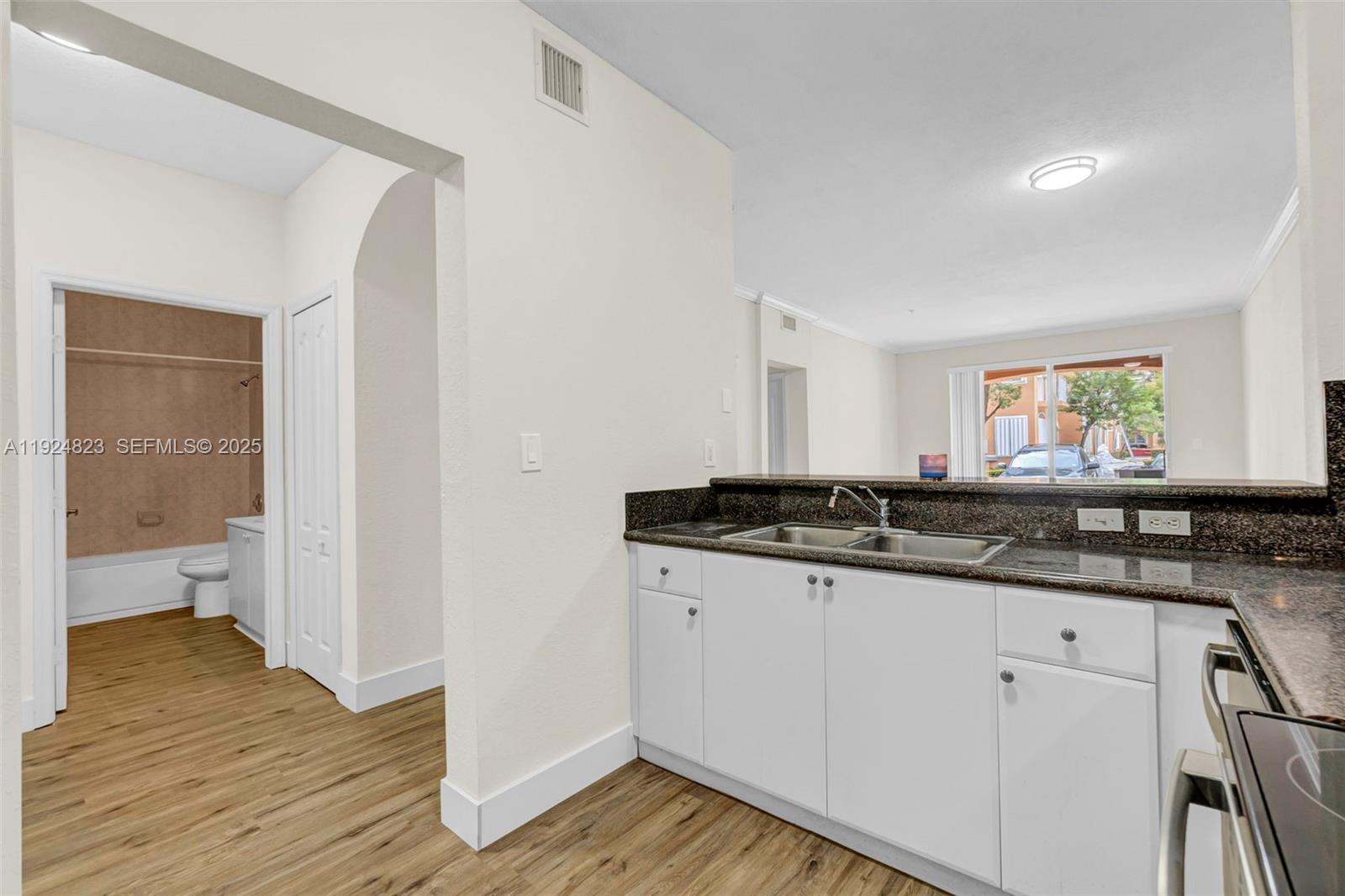 7250 Northwest 177th Street, Unit 10216 Hialeah, FL 33015 - Photo 4 of 23 a kitchen with granite countertop a sink and cabinets