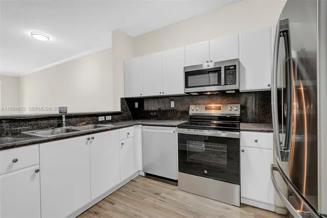 a kitchen with stainless steel appliances granite countertop a refrigerator stove and microwave