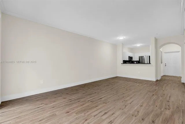 a view of a kitchen with wooden floor and electronic appliances