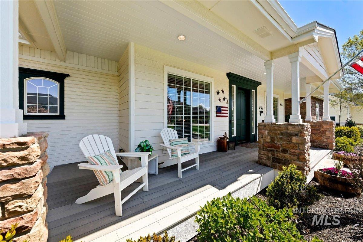 414 East Shafer View Drive Meridian, ID 83642 - Photo 4 of 50 Covered front porch featuring an 8 ft. tall dark green front door, sidelight windows, recently painted wood siding, and stone-wrapped porch columns