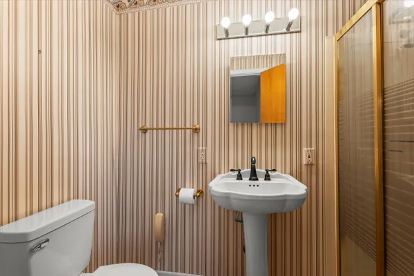 a bathroom with a sink a toilet and mirror
