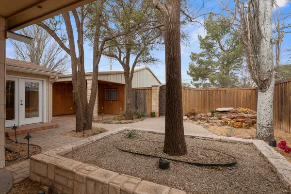a backyard of a house with fountain table and chairs