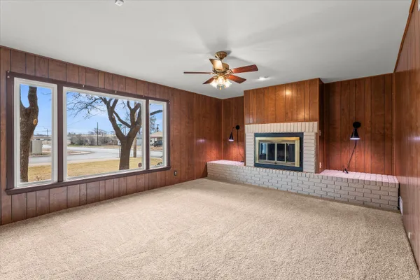 an empty room with windows and fireplace