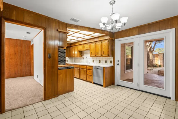 a very nice looking open kitchen with stainless steel appliances granite countertop a refrigerator and a stove top oven