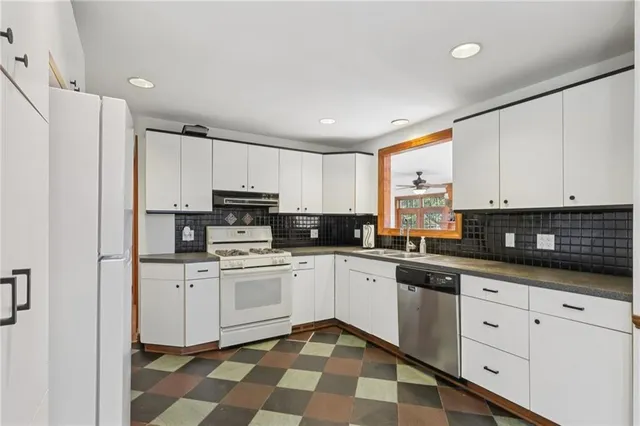 a kitchen with granite countertop white cabinets and white appliances