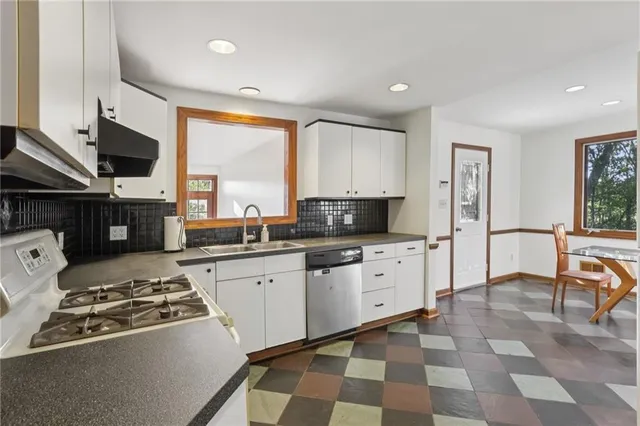 a kitchen with stainless steel appliances granite countertop a stove a sink and a refrigerator