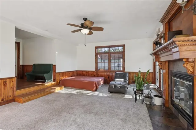 a spacious bedroom with a bed a fireplace and a chandelier