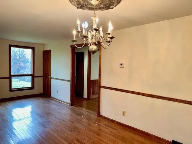 a view of a room with wooden floor and chandelier