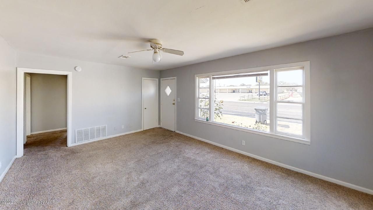 4309 South Washington Street Amarillo, TX 79110 - Photo 2 of 12 an empty room with chandelier fan and windows