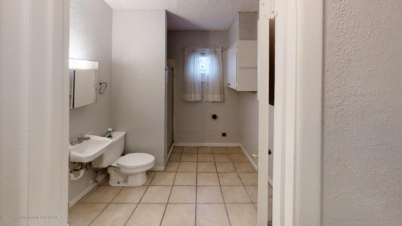 4309 South Washington Street Amarillo, TX 79110 - Photo 7 of 12 a bathroom with a toilet and a shower