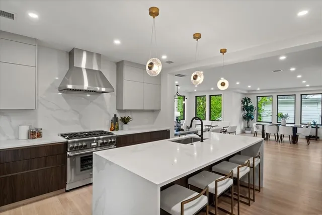 a kitchen with stainless steel appliances a dining table and stove top oven