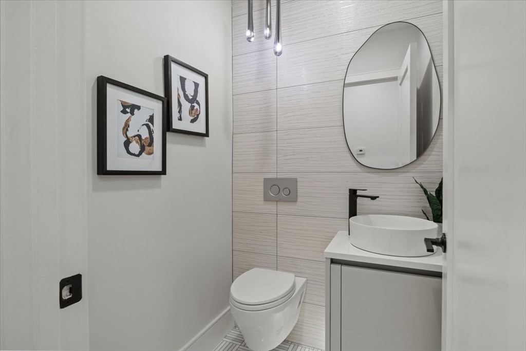 116 Thorndike Street Brookline, MA 02446 - Photo 11 of 42 a bathroom with a toilet sink and mirror