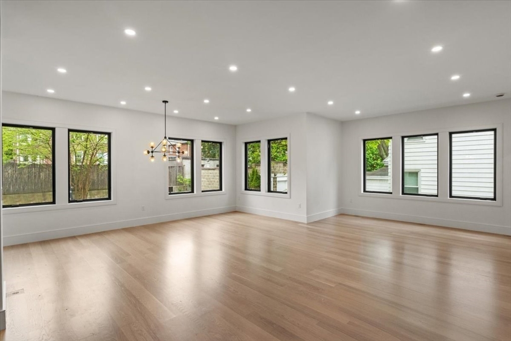 116 Thorndike Street Brookline, MA 02446 - Photo 24 of 42 an empty room with wooden floor and windows