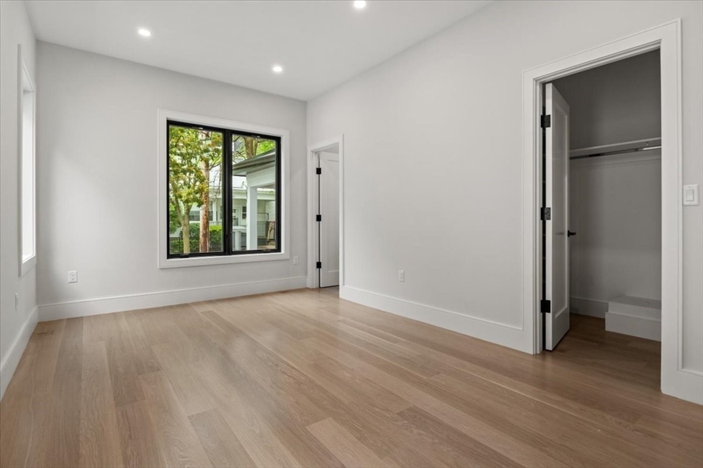 116 Thorndike Street Brookline, MA 02446 - Photo 28 of 42 an empty room with wooden floor and a window