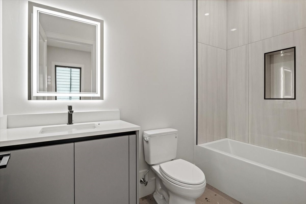 116 Thorndike Street Brookline, MA 02446 - Photo 29 of 42 a bathroom with a granite countertop sink toilet and mirror