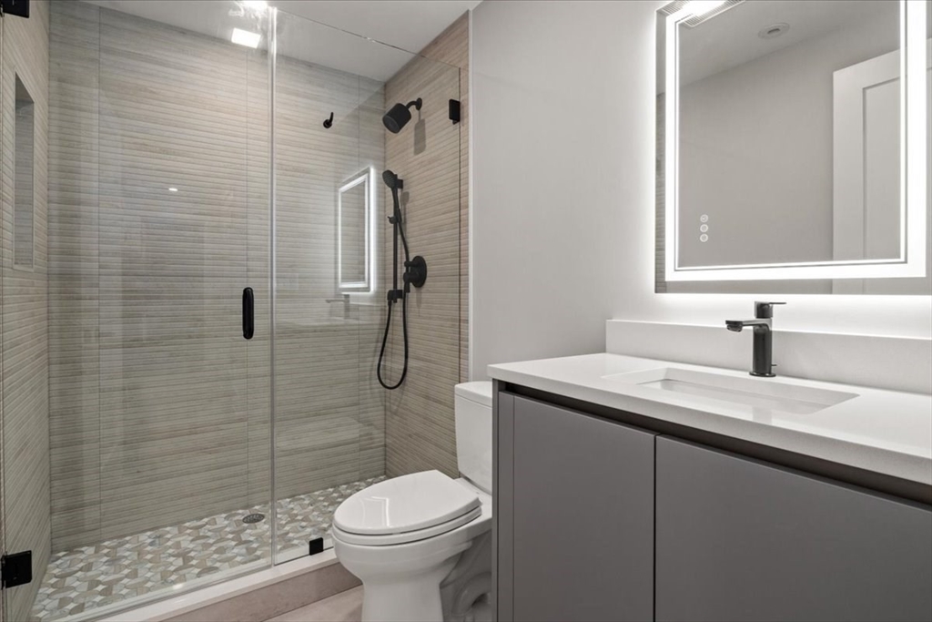 116 Thorndike Street Brookline, MA 02446 - Photo 35 of 42 a bathroom with a granite countertop sink toilet and shower