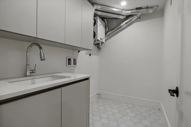 a view of a white house with large windows and a tree