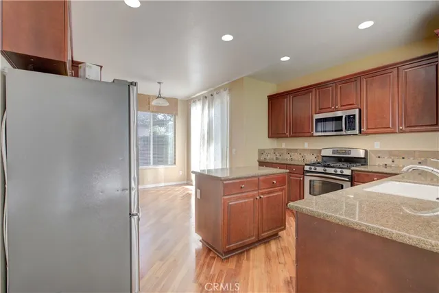 a kitchen with stainless steel appliances granite countertop a refrigerator stove microwave and sink