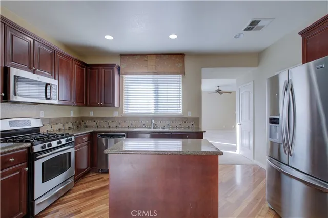 a kitchen with stainless steel appliances granite countertop a stove a sink and a refrigerator
