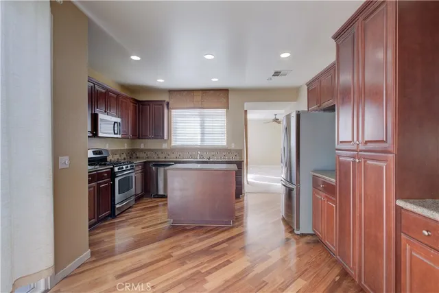 a kitchen with stainless steel appliances granite countertop a refrigerator a stove top oven a sink and dishwasher