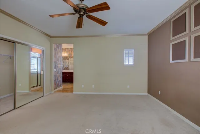 an empty room with chandelier fan