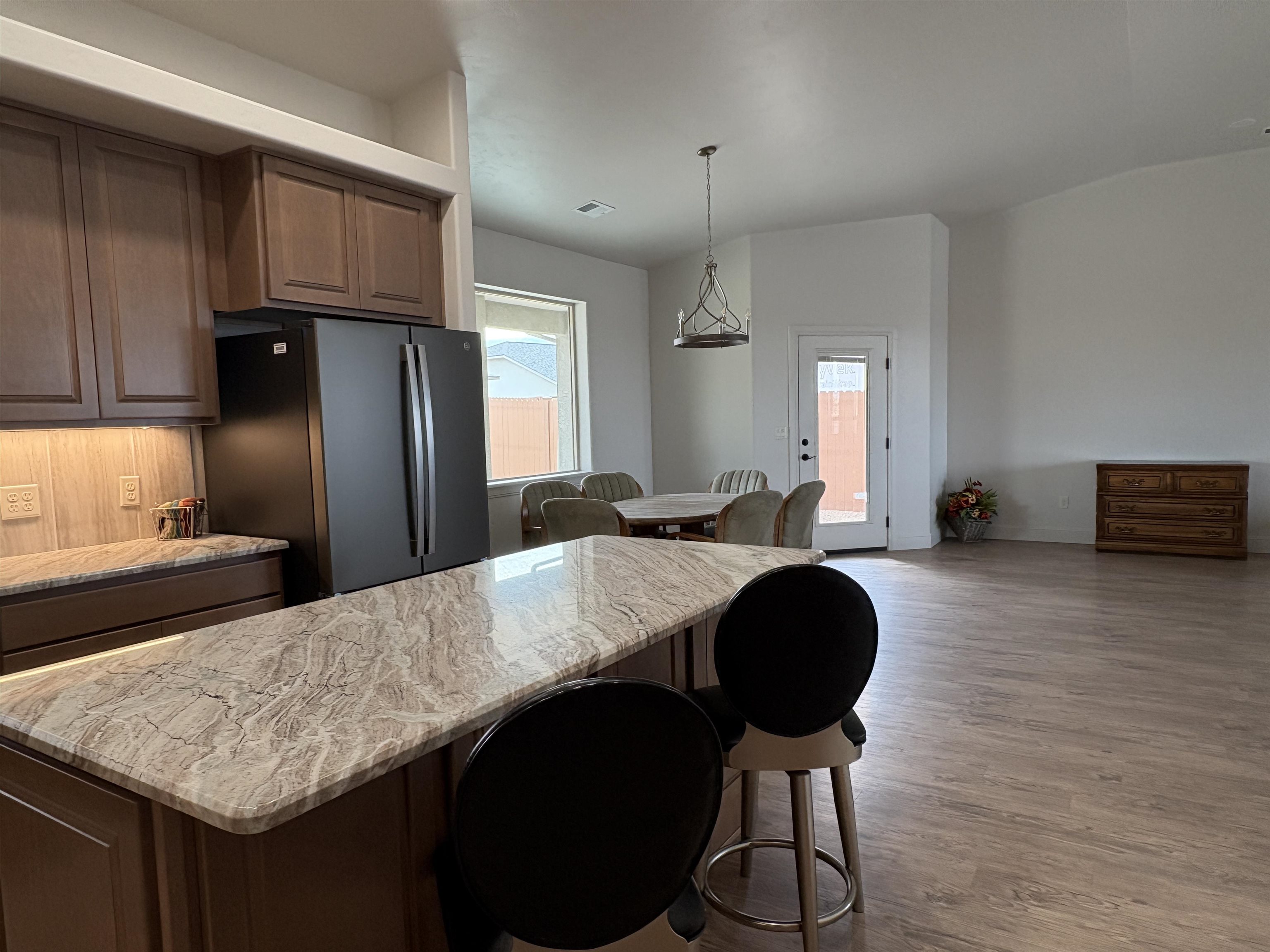 2629 Emerald Ridge Lane Grand Junction, CO 81506 - Photo 11 of 36 a kitchen with stainless steel appliances granite countertop a table chairs in it and wooden floors