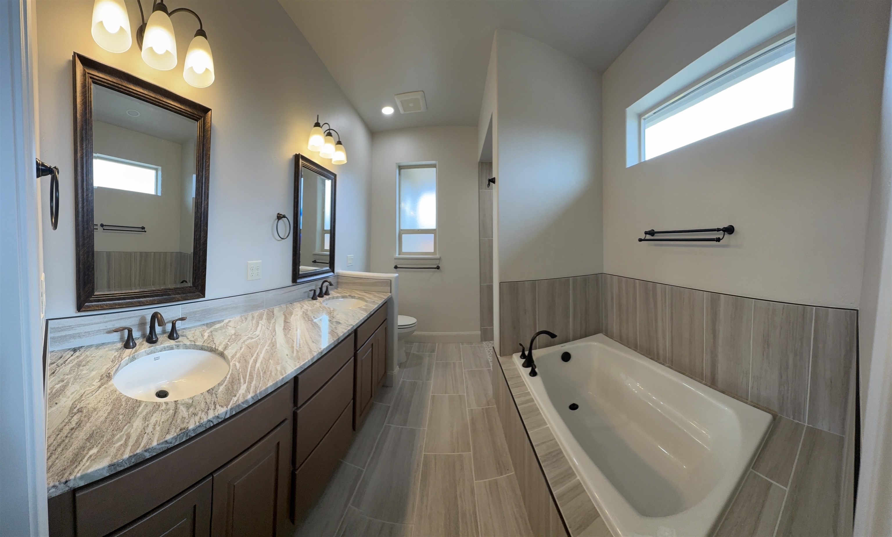 2629 Emerald Ridge Lane Grand Junction, CO 81506 - Photo 21 of 36 a spacious bathroom with a granite countertop tub sink and mirror