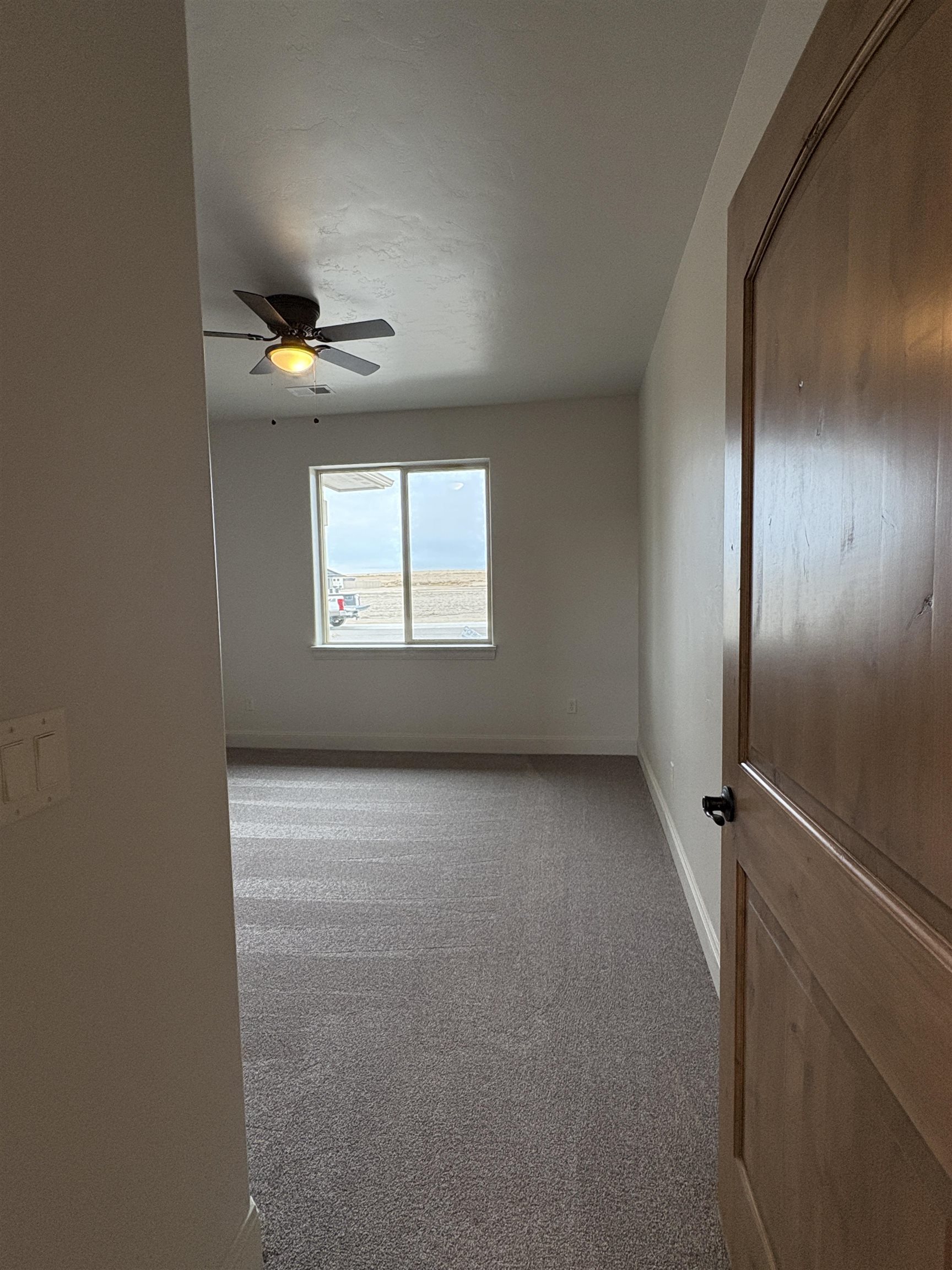 2629 Emerald Ridge Lane Grand Junction, CO 81506 - Photo 22 of 36 an empty room with windows and ceiling fan