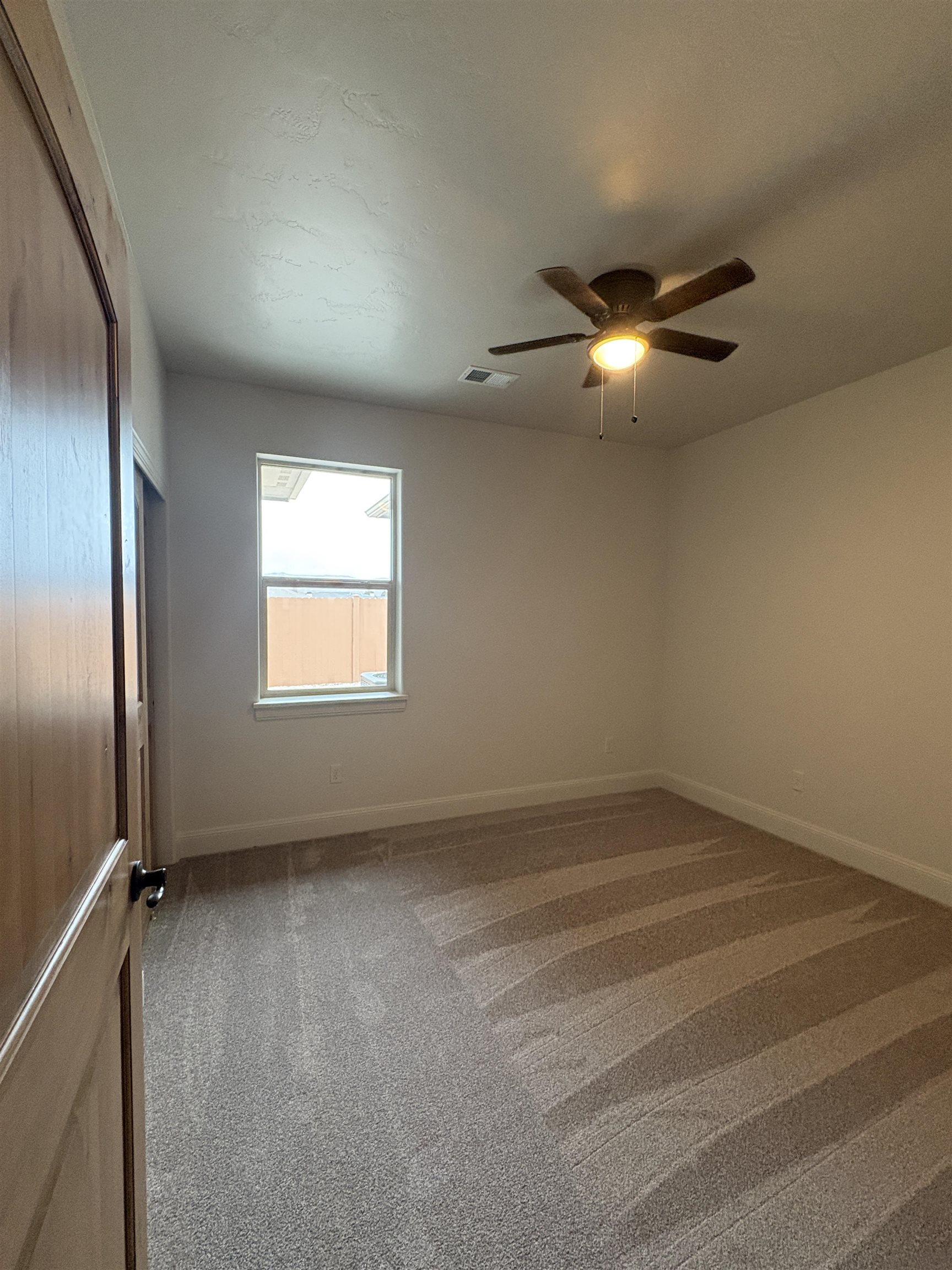 2629 Emerald Ridge Lane Grand Junction, CO 81506 - Photo 24 of 36 an empty room with a chandelier fan and windows