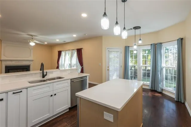 a kitchen with a sink chandelier and wooden floor
