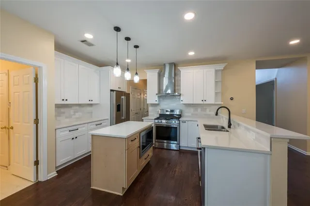 a kitchen with kitchen island a sink stainless steel appliances and cabinets