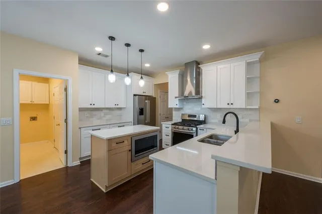 a kitchen with a sink a stove a refrigerator and white cabinets