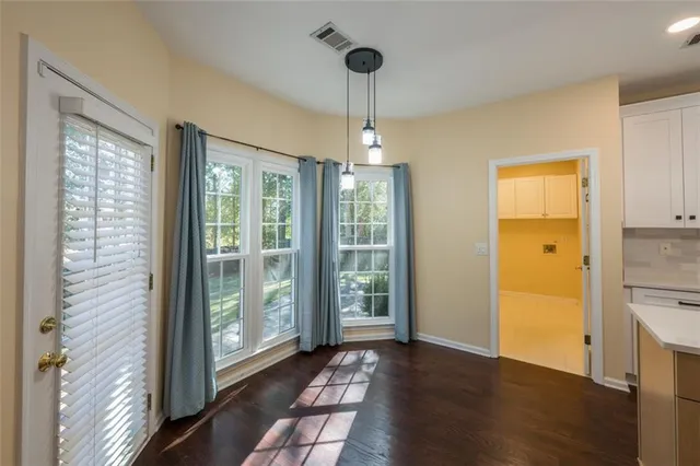 a view of a hallway with wooden floor and a chandelier
