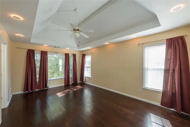 a view of an empty room with a window and wooden floor