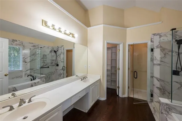a bathroom with a double vanity sink a large mirror and shower