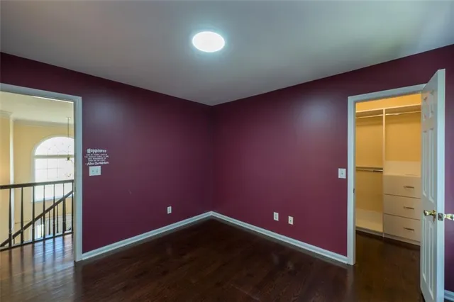 an empty room with wooden floor and natural light