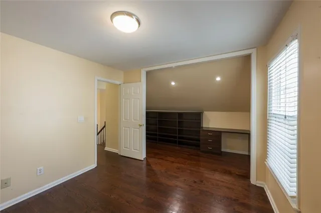 an empty room with wooden floor and a window