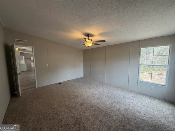 a view of a livingroom with a ceiling fan and window