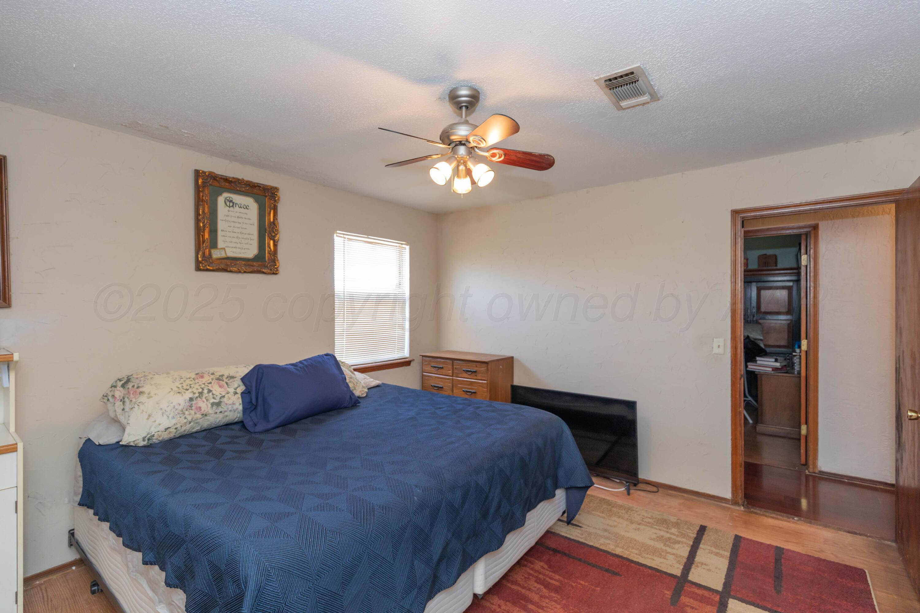 609 Groom Avenue Panhandle, TX 79068 - Photo 14 of 28 a bedroom with a bed and wooden floor