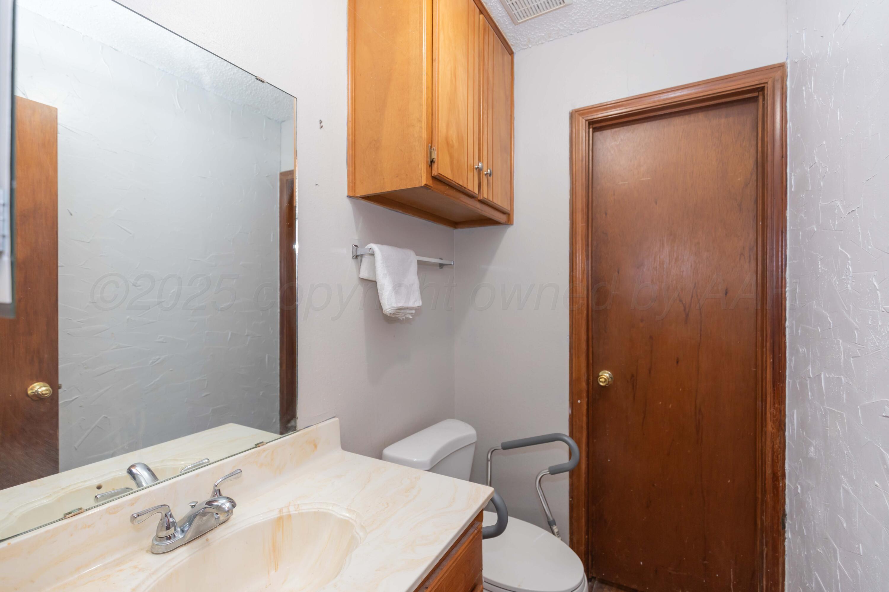 609 Groom Avenue Panhandle, TX 79068 - Photo 15 of 28 a bathroom with a sink a toilet and shower curtain