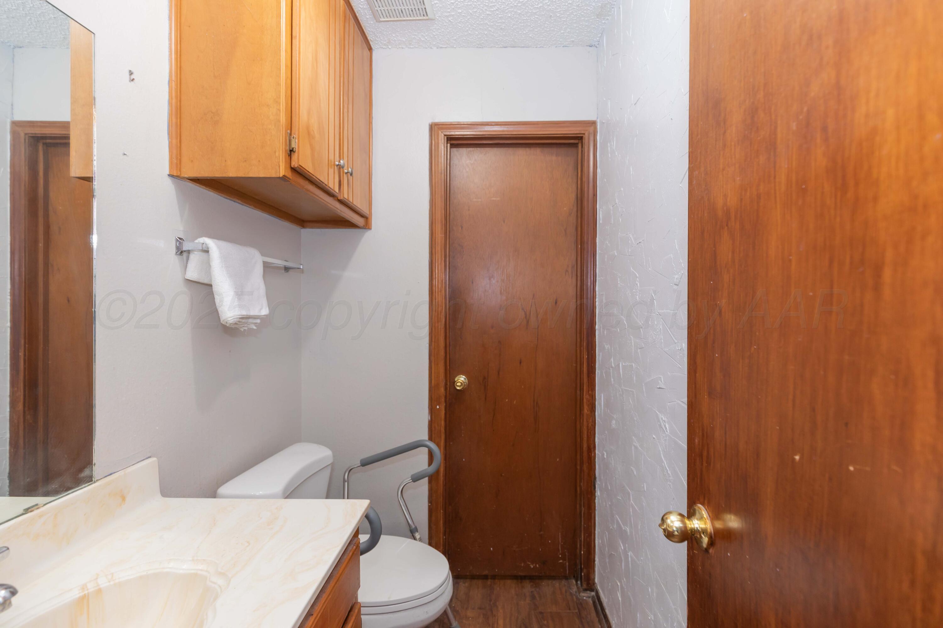 609 Groom Avenue Panhandle, TX 79068 - Photo 16 of 28 a bathroom with a toilet a sink and mirror