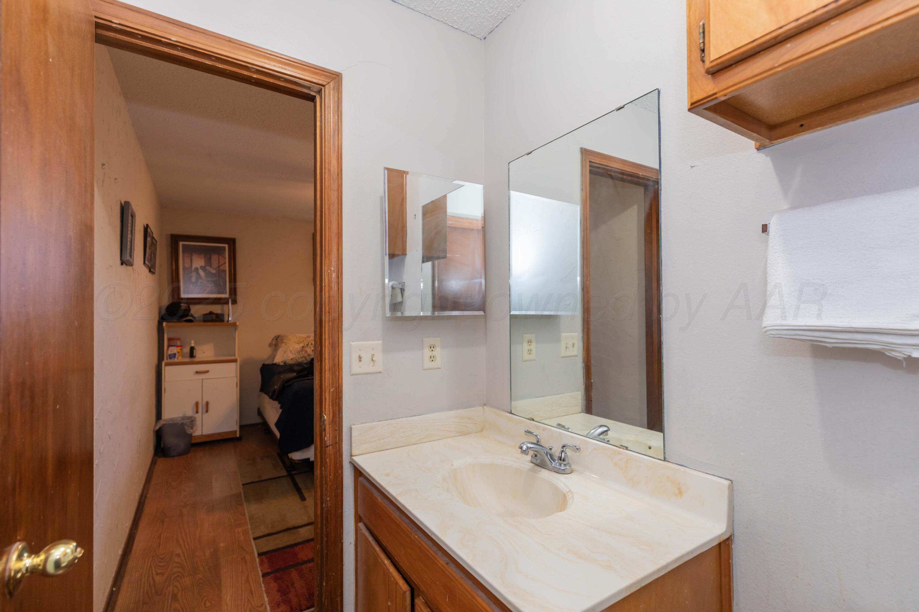 609 Groom Avenue Panhandle, TX 79068 - Photo 17 of 28 a en suite bathroom with a sink and a mirror